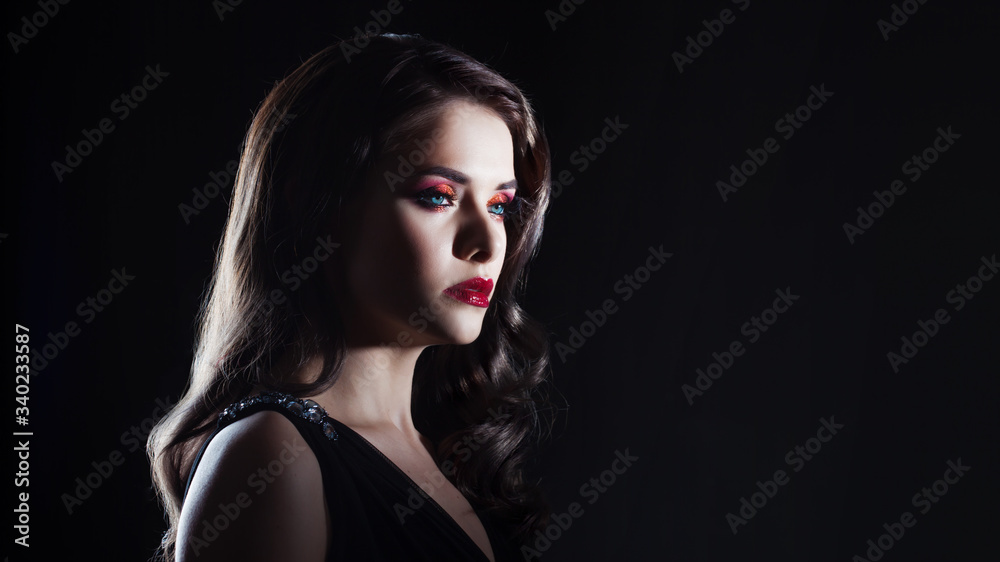 Portrait of a young luxurious woman in a low key. Bright makeup with scarlet lipstick, hairstyle with curls, Portrait of a young luxurious woman in a low key. Bright makeup with scarlet lipstick, hairstyle with curls,