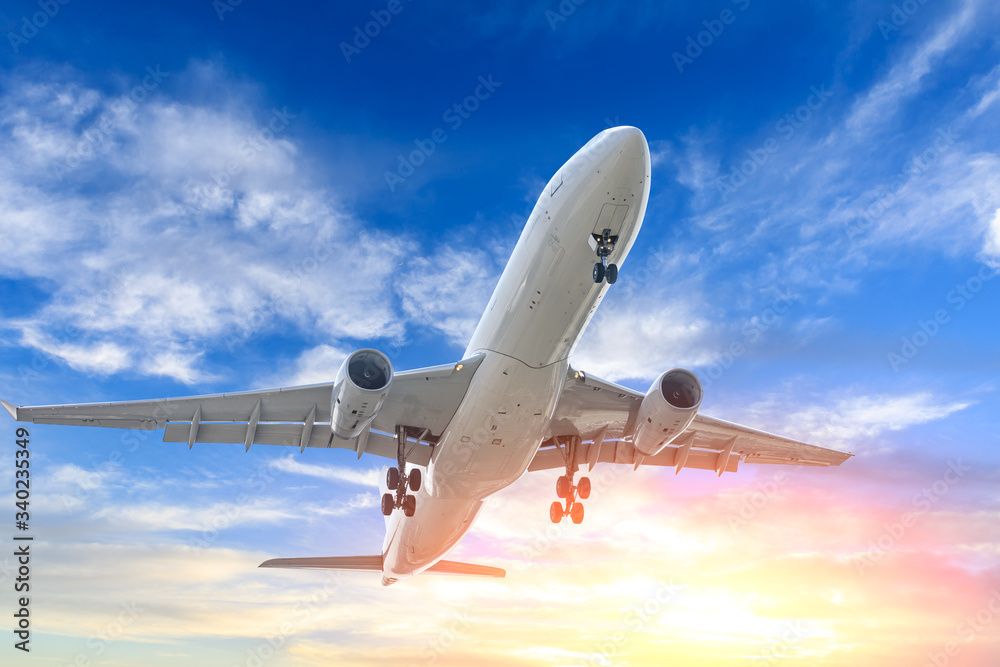 Fototapeta premium Commercial airplane flying in beautiful sky at sunset,travel concept.