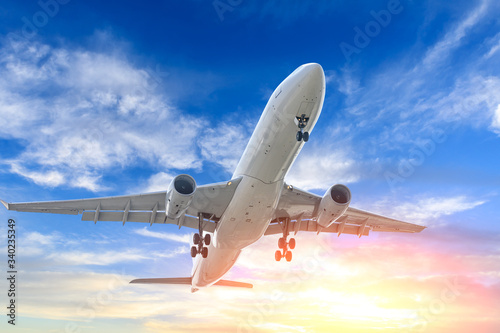 Commercial airplane flying in beautiful sky at sunset,travel concept.