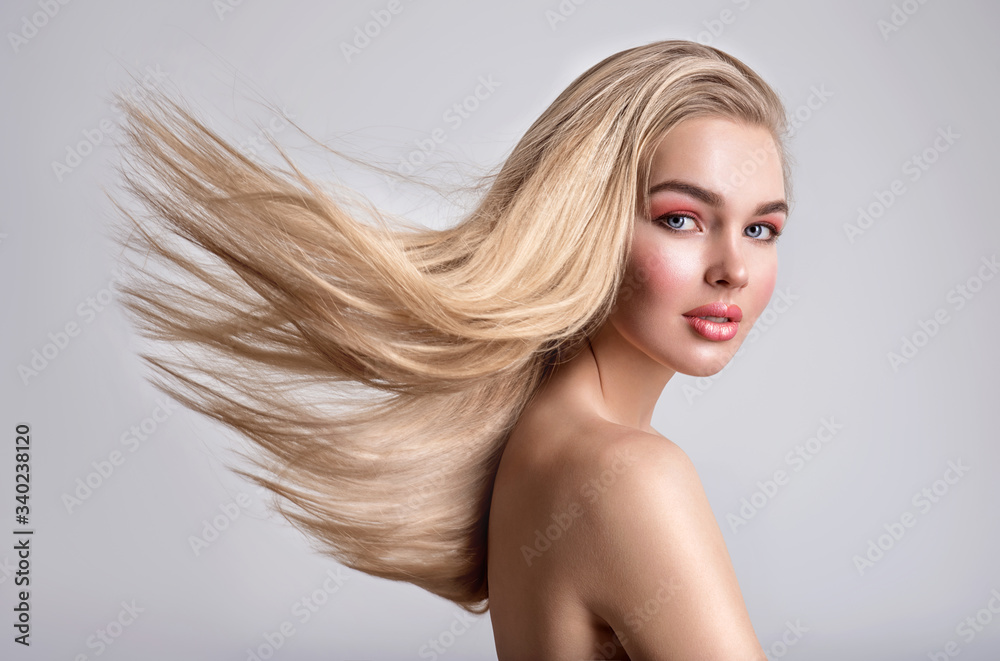 Portrait of a blonde beautiful woman with a long straight light hair. Flying hair.