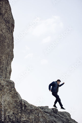 A young man is jumping on a rock