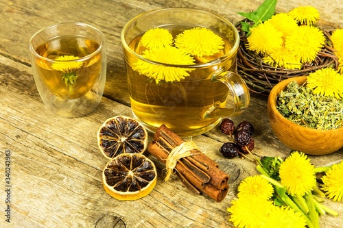 Herbal tea infusion of fresh dandelion leaf, with yellow blossoms. Medicinal plant dandelion (Taraxacum officinale). Traditional medicine. Medicinal herb.