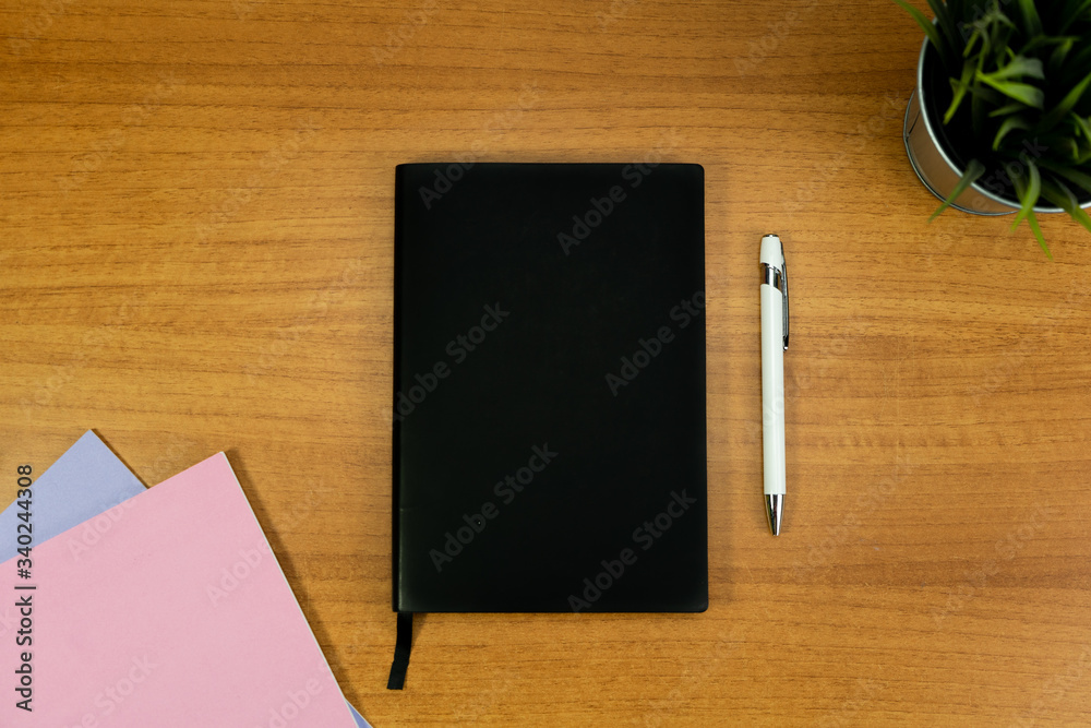 Stationery set with A5 paper notebook with black cover and white pen for mockup purposes Stationery set with A5 paper notebook with black cover and white pen for mockup purposes
