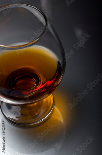 Cognac in a glass. Wine in a glass. Cognac in the dark key. Noble alcohol. Port in a glass on the table.
