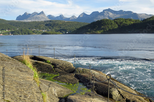 Mighty whirlpools of the strongest tidal current of the world - Saltstraumen in Norway, Europe - in front of the beautiful mountain landscape
 photo