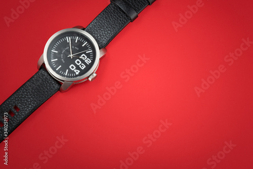 Modern male watch on red background