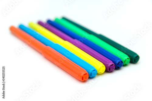 Colorful markers lying in a row on a white background. Art and education.