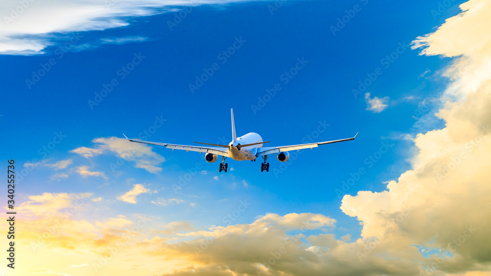 Commercial airplane flying in beautiful sky at sunset,travel concept.