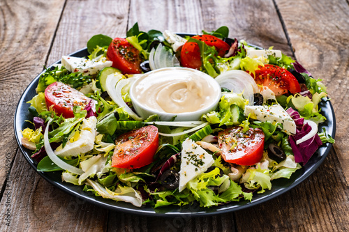 Fresh salad - blue cheese and vegetables on wooden table 