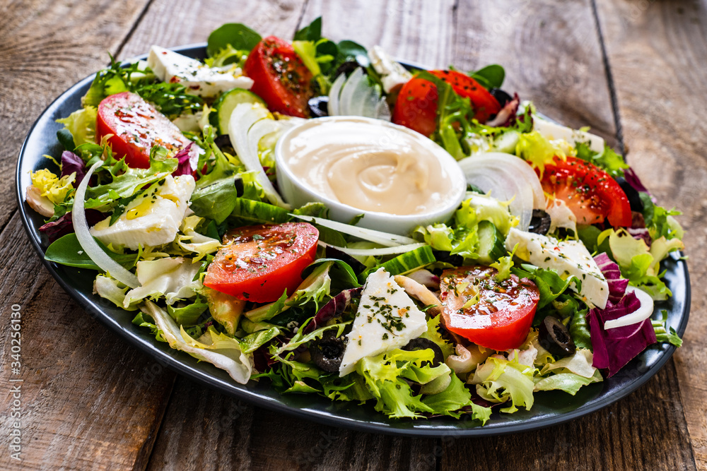 Fresh salad - blue cheese and vegetables on wooden table
Fresh salad - blue cheese and vegetables on wooden table