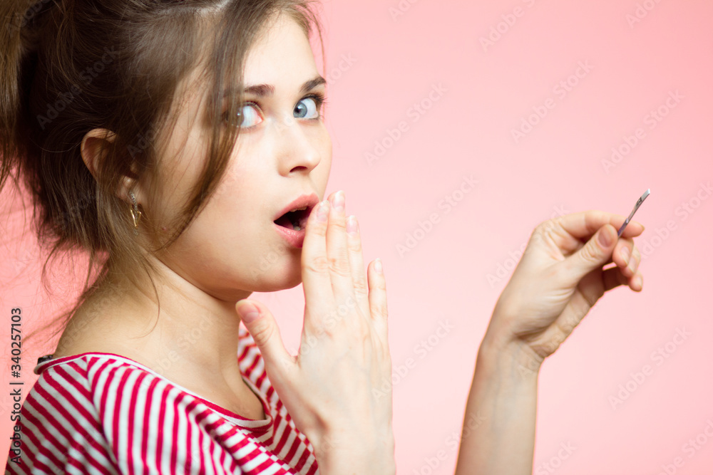 funny young woman shocked with medical pregnancy test result, female covers her mouth in surprise on a colored studio background, concept of motherhood and family planning funny young woman shocked with medical pregnancy test result, female covers her mouth in surprise on a colored studio background, concept of motherhood and family planning