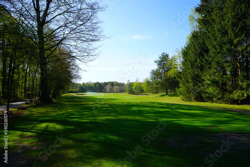 Blick auf einen leeren Golfplatz / Golfbahn mit Rasensprenger im Frühling 