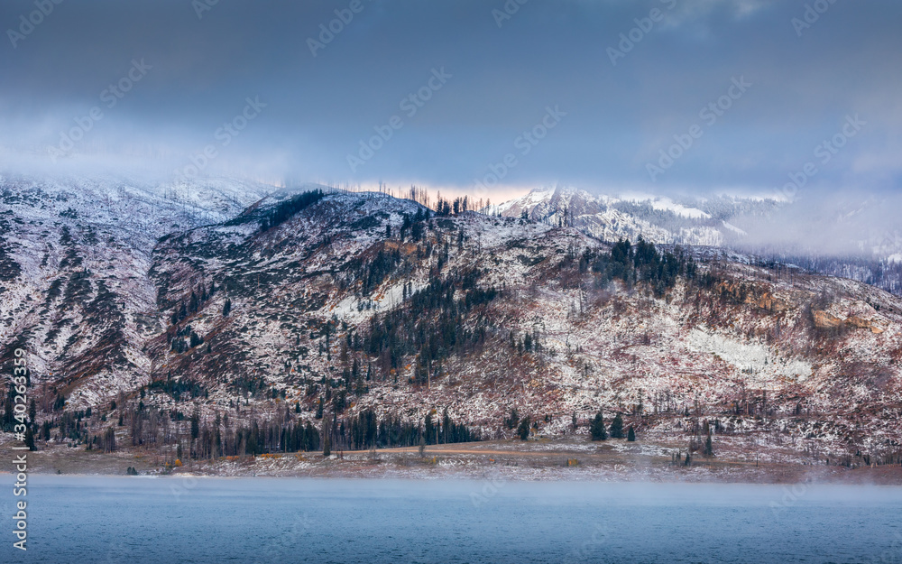 Mountain range covered by snow and cloud inside forest during autumn of Grand Teton.