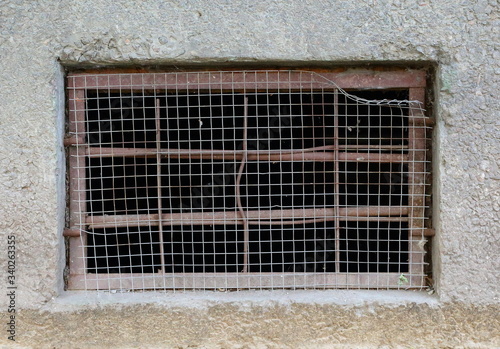 A basement window with a metal barrier