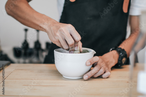 A brush made of bamboo and a teacup with green tea called matcha on wooden tray made by professional barista in Asian cafe.Green tea powder being stir in a white ceramic bowl.Tea ceremony in oriental 