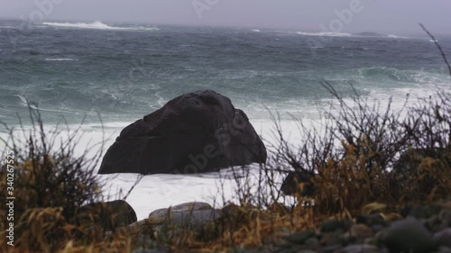 Waves Crashing On A Rock By The Coast Of Arendal In Norway On A Stormy Day - wide shot photo