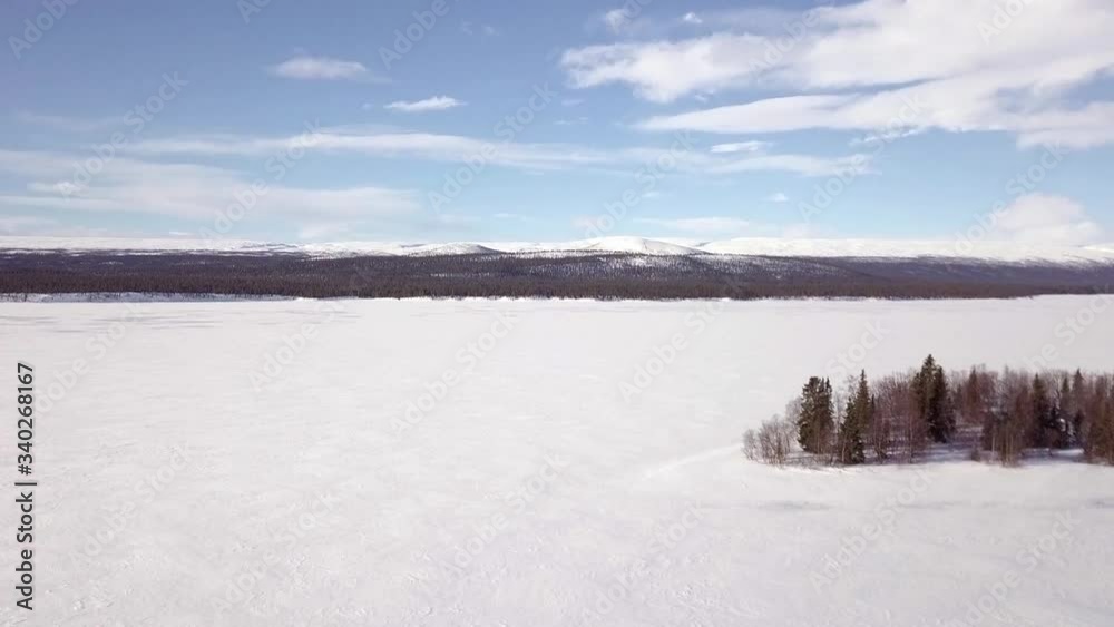 The beautiful, bright white frozen lake in Sjöfallet National Park in Lapland, Sweden during winter - aerial The beautiful, bright white frozen lake in Sjöfallet National Park in Lapland, Sweden during winter - aerial