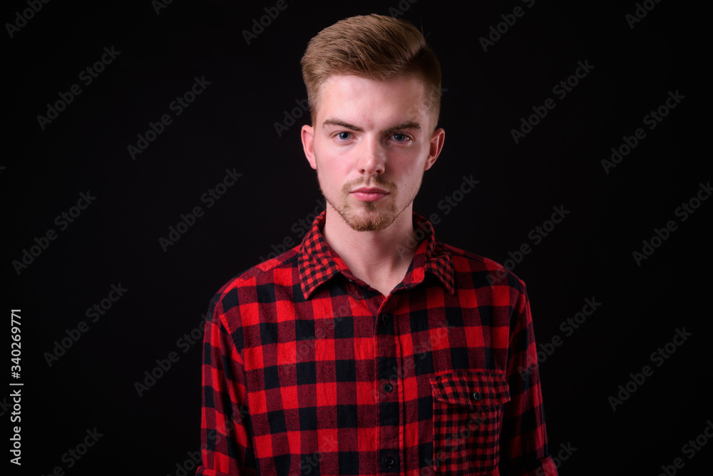 Portrait of young handsome blond bearded hipster man