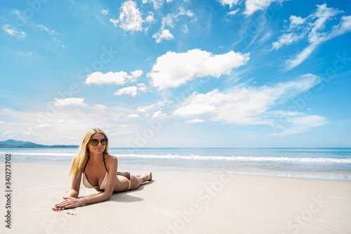 Young beautiful woman relaxing on the tropical beach. Tropical vacation concept.. © upslim