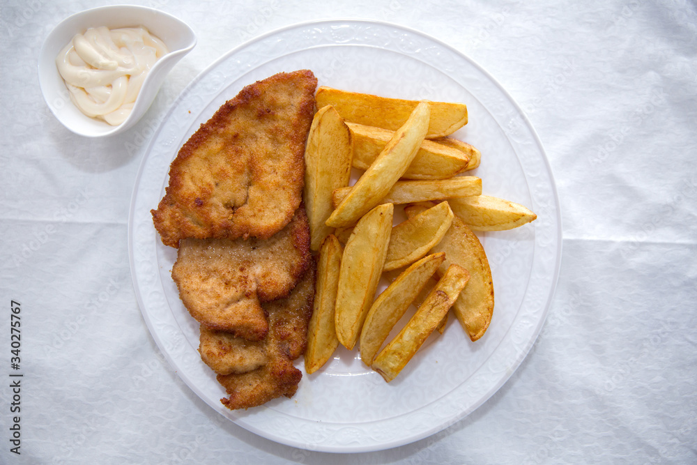 Fried chicken cutlet. Fry the potatoes in a white plate . Red Dry Pepper in Traditional Basket . Mayonnaise inside a bowl . Fried chicken cutlet. Fry the potatoes in a white plate . Red Dry Pepper in Traditional Basket . Mayonnaise inside a bowl .