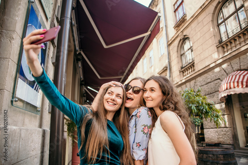 Three young women are walking in the city and having fun. Summer mood © Mila