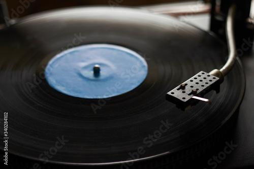 Close-up of blue music record on turntable, turntable needle playing music, selective focus