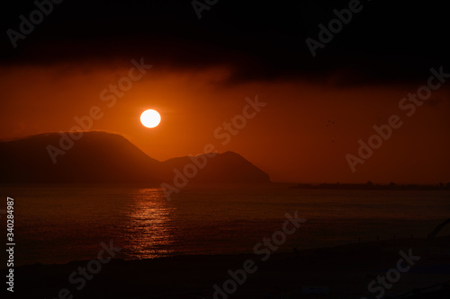 Fiery sun at sunset over pacific ocean in Peru
