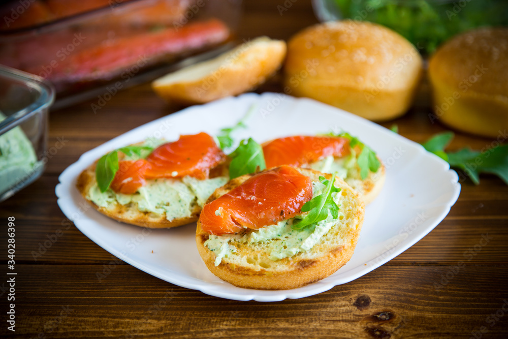 sandwich with fried bun, cheese spread and red fish in a plate sandwich with fried bun, cheese spread and red fish in a plate