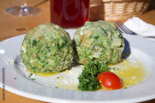 Foto two fresh delicious green spinach dumplings on a plate with tomato and parsley h