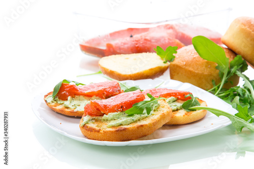 sandwich with fried bun, cheese spread and red fish in a plate