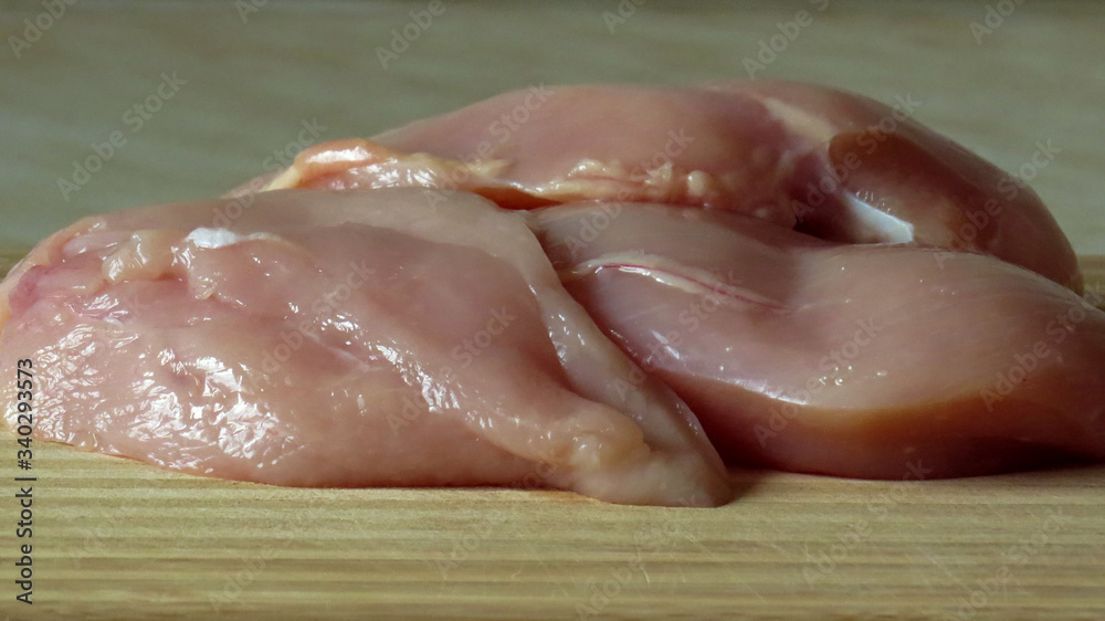 Fresh raw chicken breasts (chicken fillet) on a wooden board. Non-GMO Chicken Fillet Fresh raw chicken breasts (chicken fillet) on a wooden board. Non-GMO Chicken Fillet