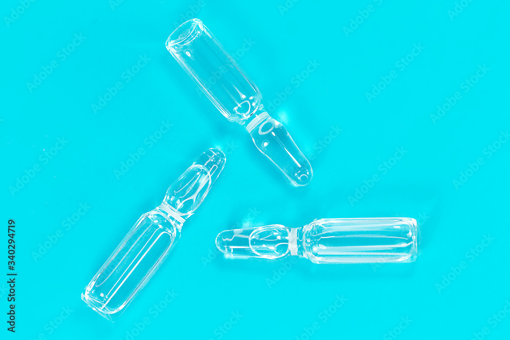 Naklejka premium Ampoule on a blue background with close-up. COVID-2019