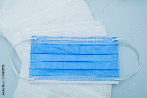 Medical face mask that help to protect mask cover the mouth and nose from virus, bacteria, dust or other pollution. the mask is taken on  mask on isolated light blue background.