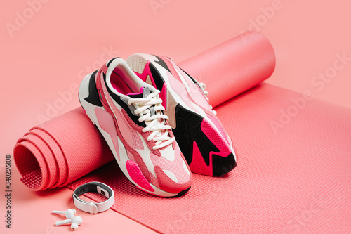 Bright fashion sneakers with  fitness bracelet and pink yoga mat. Healthy lifestyle. © igishevamaria