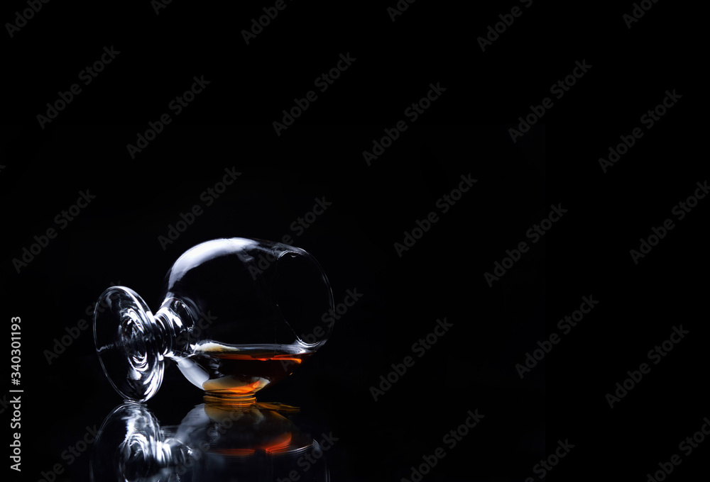 glass of snifter with whiskey on a black background glass of snifter with whiskey on a black background
