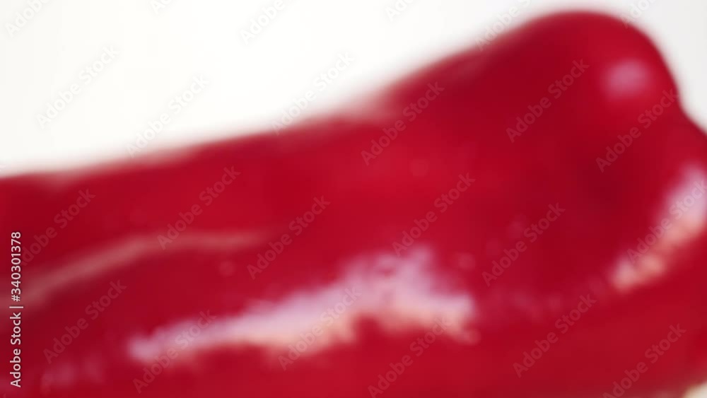 Rotating Fresh Raw Ramiro Red Chili Pepper On A White Plate With Drops Water. Rotating Fresh Raw Ramiro Red Chili Pepper On A White Plate With Drops Water.