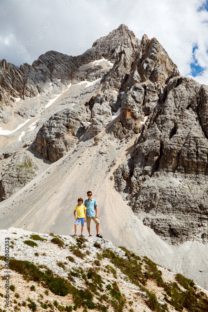 Two boys walk in mountains, Italy