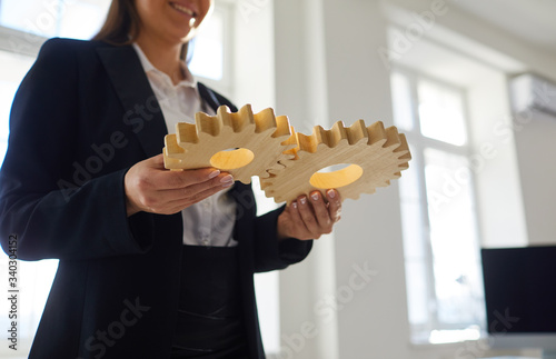 Crop business people stacking cogwheels in team