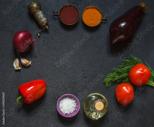Circular layout of fresh vegetables and spices on a black background
