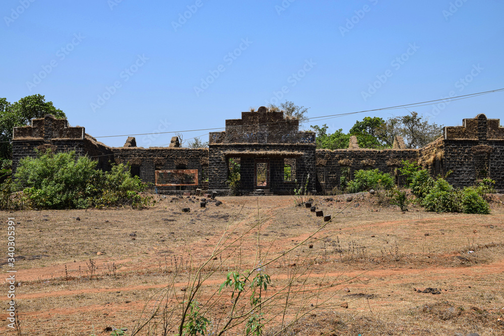 Front view of old demolished house wall constructed using black stone