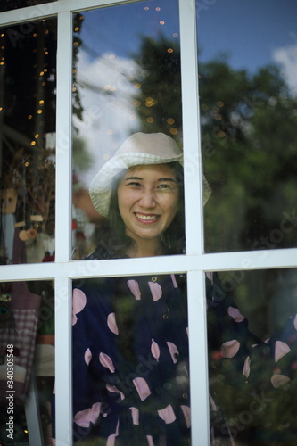 A woman smiling through a glass window