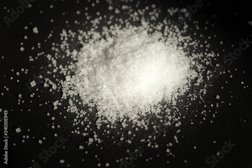 Pile of white sea salt on black background