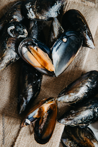 Fresh uncooked raw big mussels on the marble table, Top view. photo