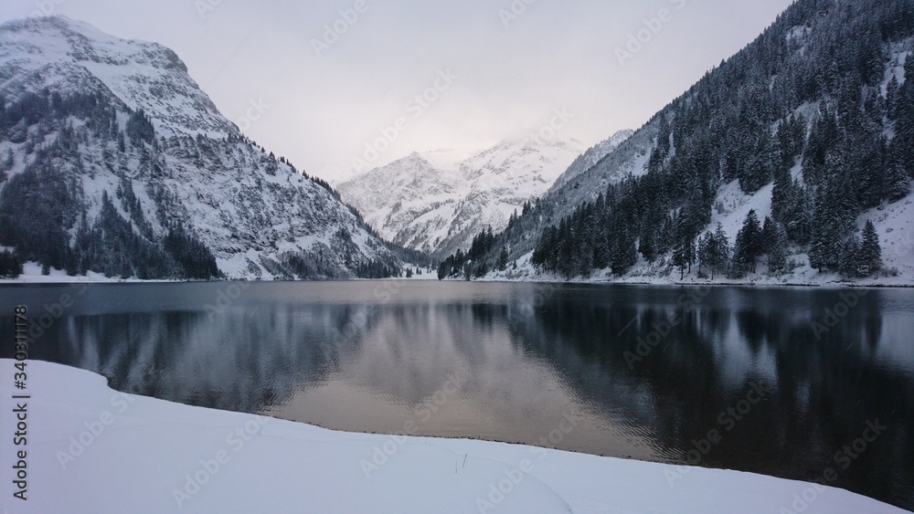 Fototapeta premium Vilsalpsee an einem ruhigen Tag umgeben von Schnee