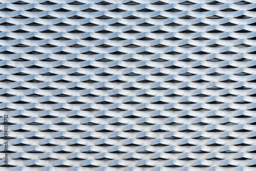 Building facade cladded with punched and perforated metal plates texture