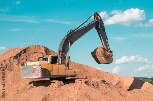 excavator loads the sand on the construction site
