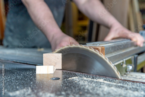 carpenter cuts wooden plank on circular saw