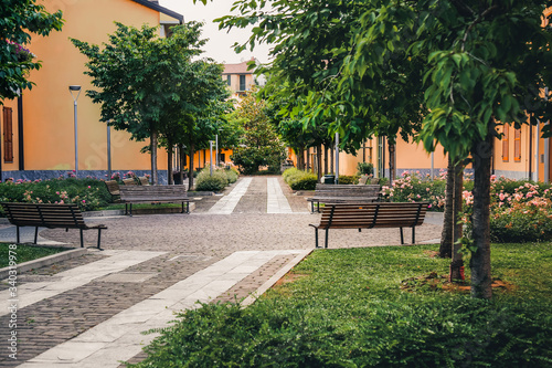 Italian street in summer. Green garden in Navigli district, Milan, Italy. Residential buildings in Europe.