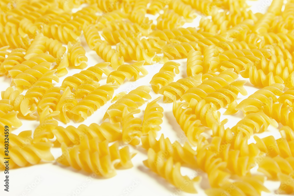 Obraz premium Raw fusilli pasta on a white background.