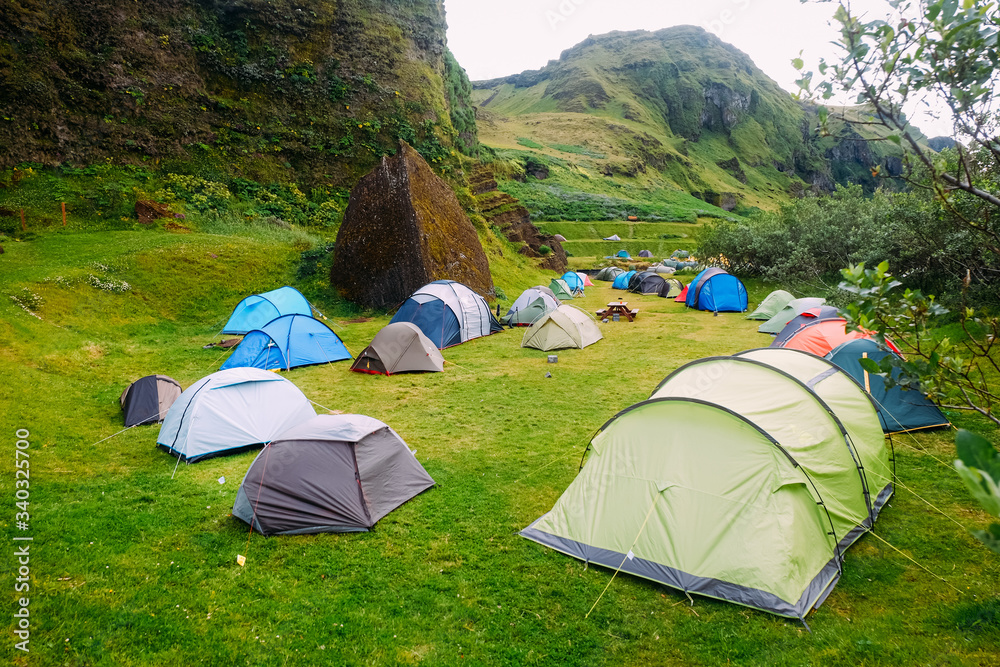 rows of multi-colored campers tents in a campsite near the mountain Gordka Vic in Iceland
